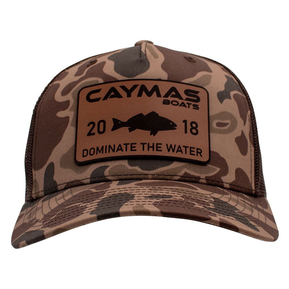 Front of a brown camouflage cap with a rectangular Caymas Boats logo patch.